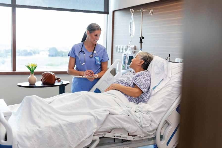 Hospital nurse checking on an elderly patient during bedside rounds to monitor recovery and provide quality patient care
