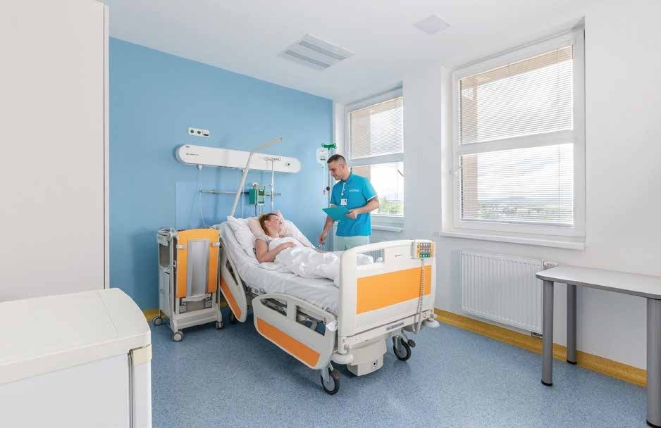 Hospital nurse checking on a patient during bedside care in a private hospital room