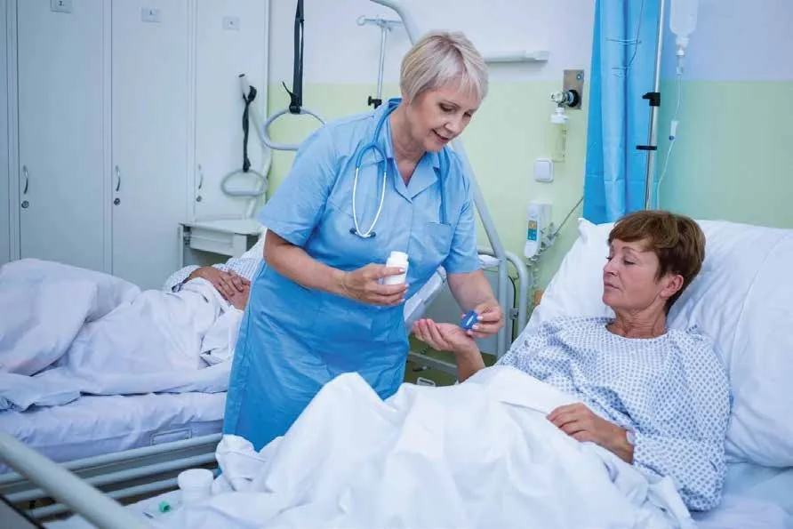 Hospital nurse administering medication to a patient during bedside care to support safe treatment and recovery