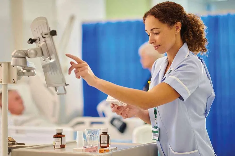 Hospital nurse preparing and verifying medication before administering it to a patient during bedside care